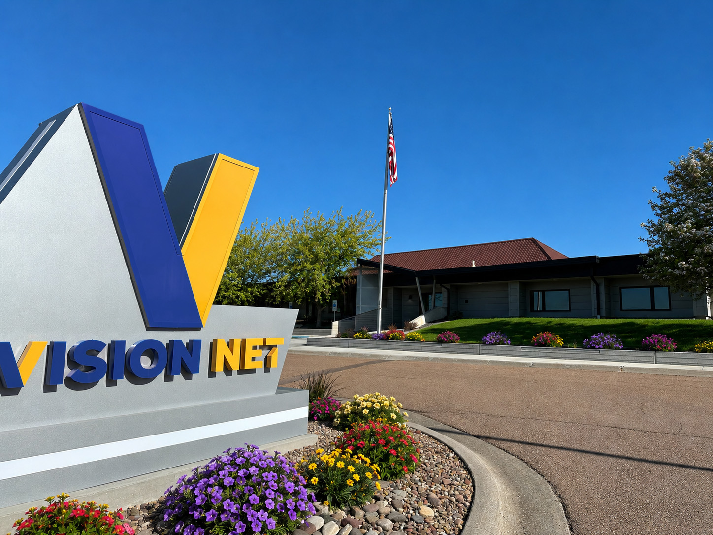 Vision Net exterior sign with flowerbeds surrounding the sign